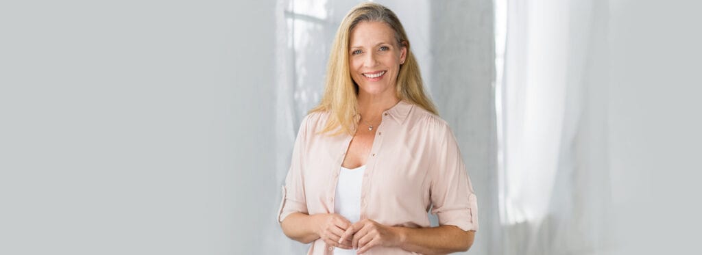 Confident woman smiling after dental implants